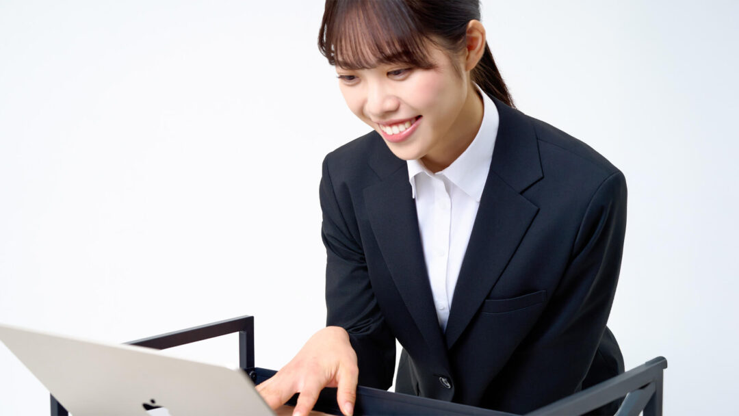 パソコンをチェックしている女性の画像