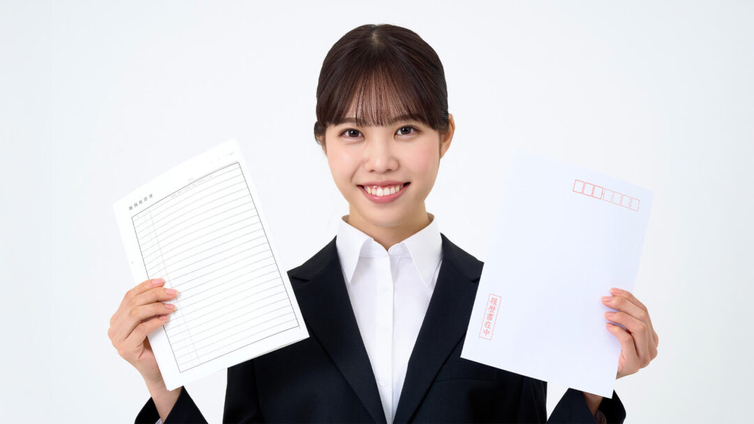 履歴書を持って微笑む女性の画像