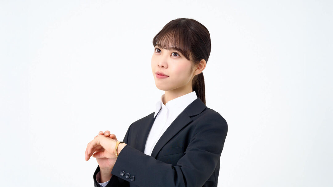 時計を気にしている女性の画像