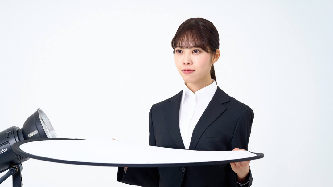 レフ板を持っている女性の画像