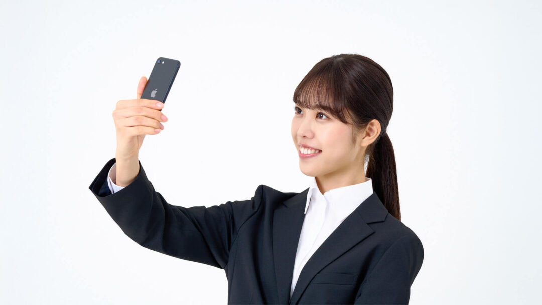 スマホで自撮りをする女性