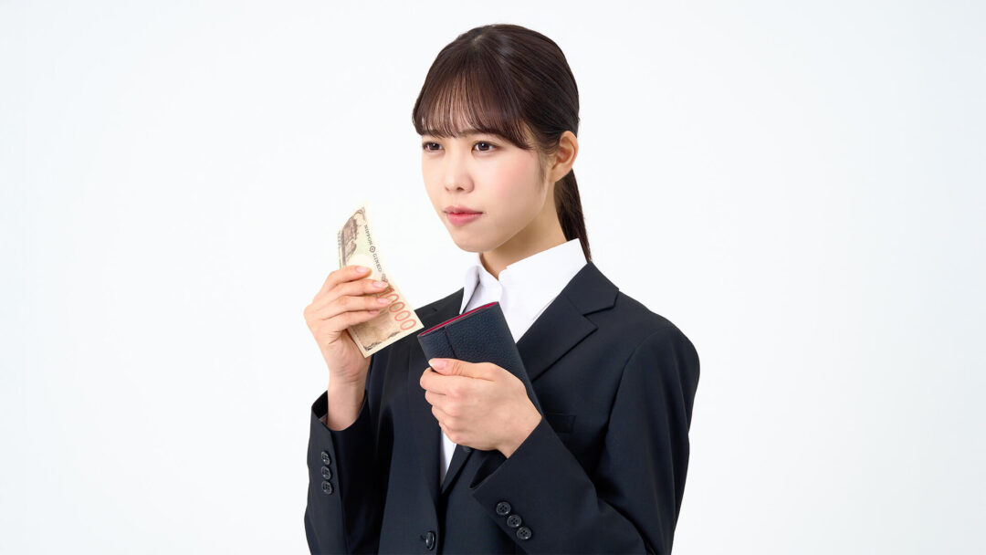 財布を持って困っている女性の画像