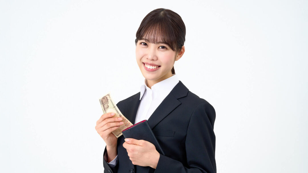 財布を持って微笑む女性の画像